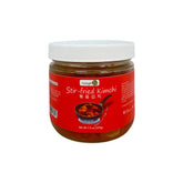 stir-fried bokkeum kimchi in a glass jar, white lid on a clean white background