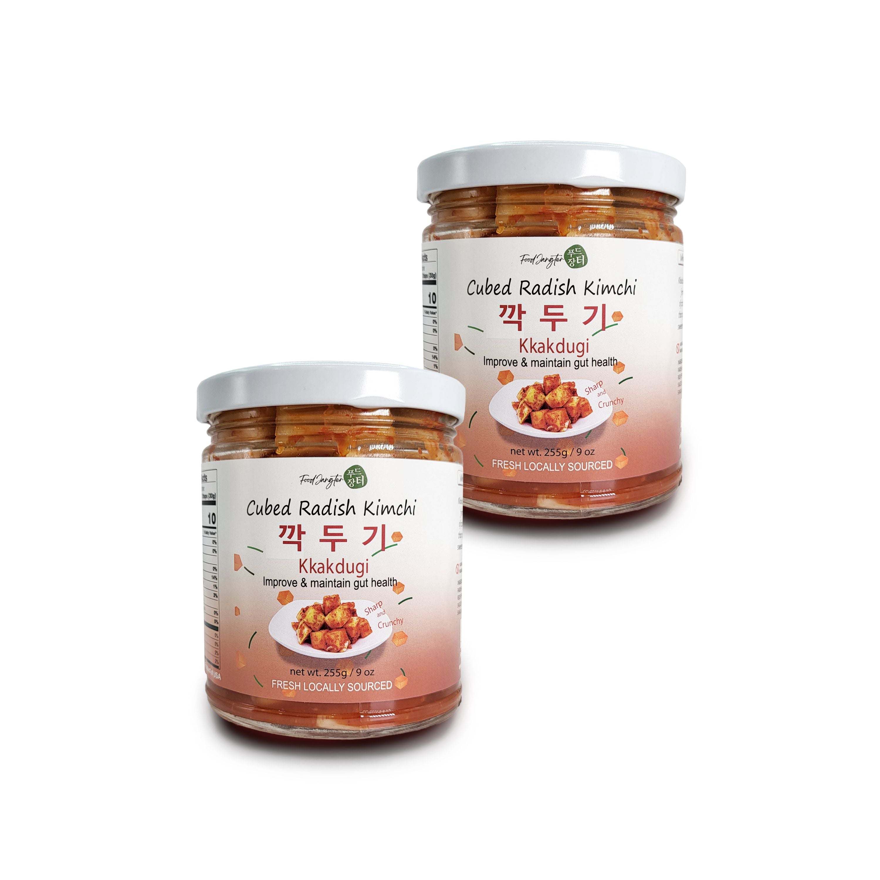 Two jars of Kkakdugi (cubed radish kimchi) on a white background