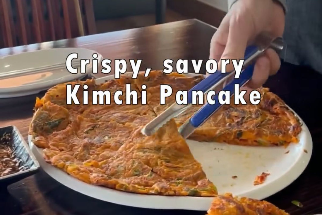 Crispy kimchi pancake served on a plate, cut into slices, with text reading “Crispy, Savory Kimchi Pancake.”